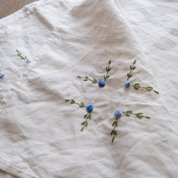 異なるニュアンスのブルーの糸で施された立体的な刺繍